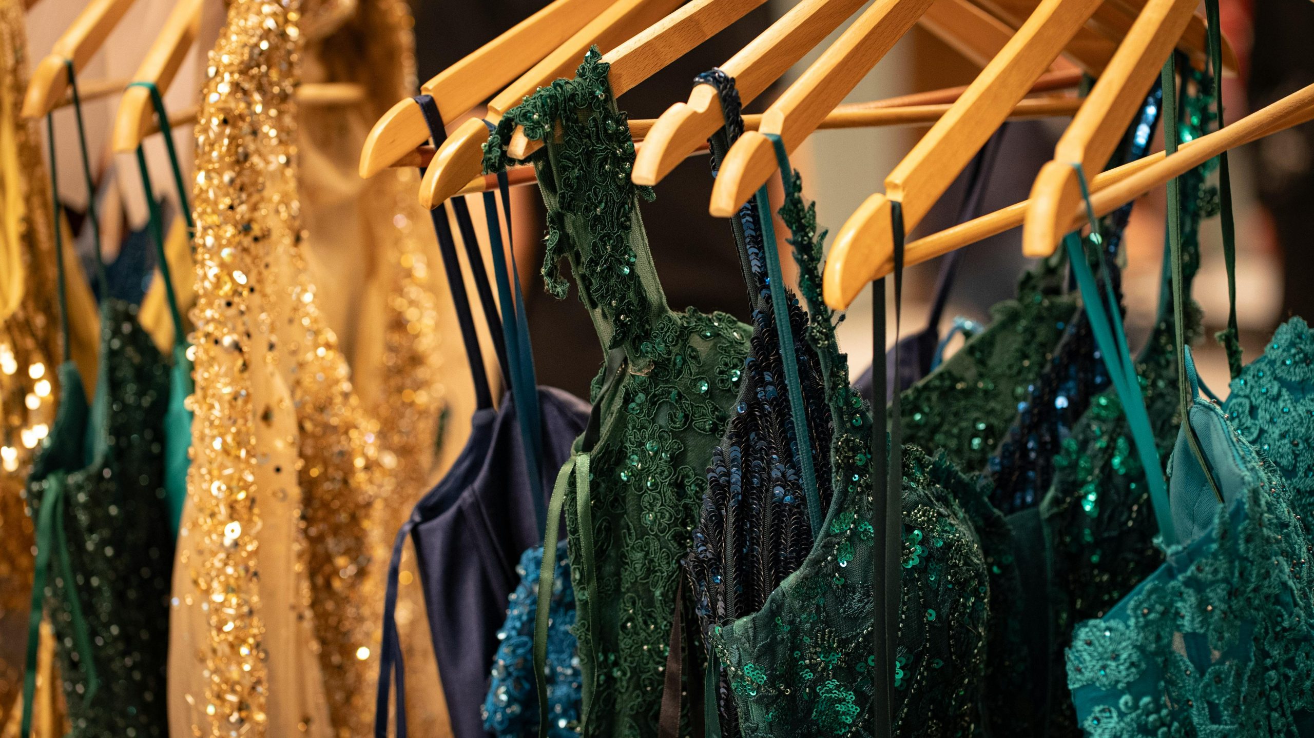 Sequin and lace evening gowns showcased at a Milan fashion event.